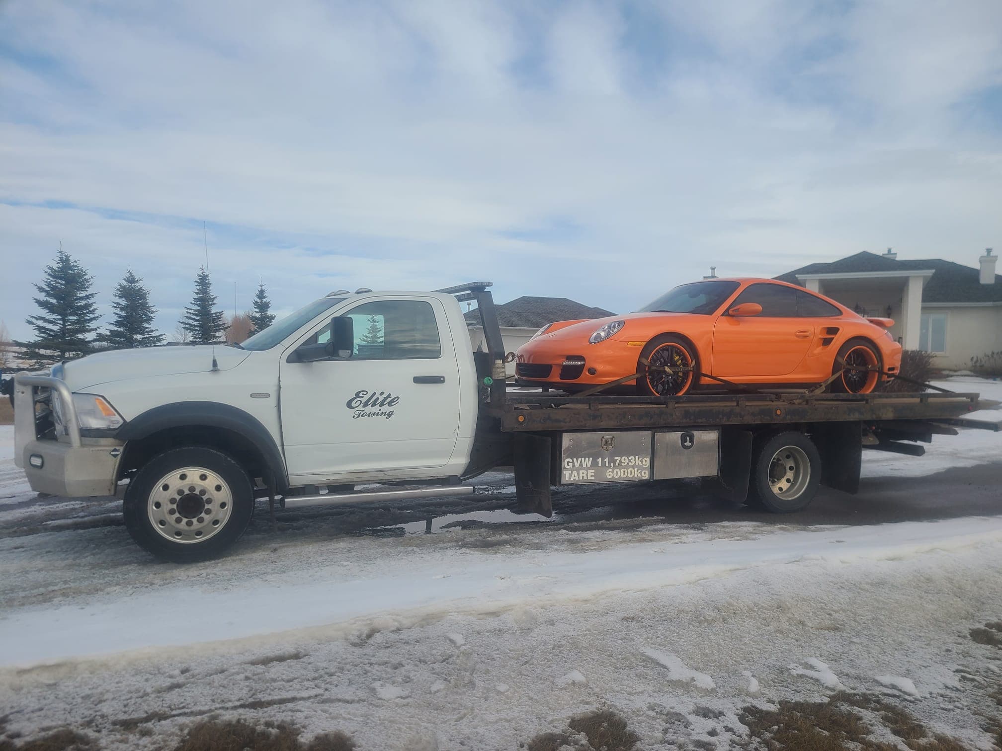 A sports car on a flatbed tow truck on an Edmonton winter day